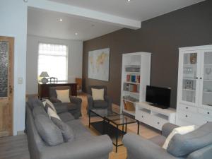 a living room with couches and a flat screen tv at Huize Ewoud in Bruges