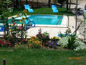 un jardín con flores y una piscina en Quinta Calcaterra, en Marialva