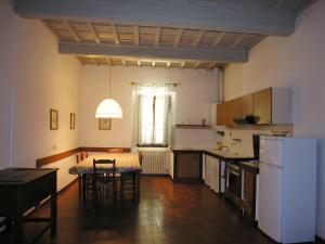uma cozinha com uma mesa e cadeiras e um frigorífico branco em Villa Senni em Scarperia