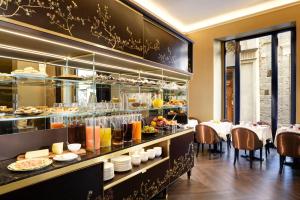a restaurant with a buffet line with food on display at San Firenze Suites & Spa in Florence