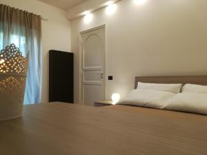 a bedroom with a bed and a table with a lamp at Luxurious Street Apartments in Catania
