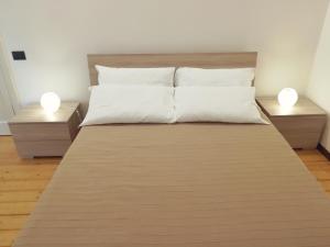 a large bed with two night stands and two lamps at Luxurious Street Apartments in Catania