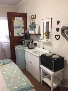 a small kitchen with a microwave on a table at 77 ON 7th Street in Hermanus