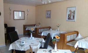 a restaurant with two tables with white tablecloths at Haus Reitz in Ernst