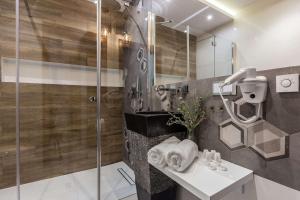 ein Bad mit einer Dusche und einem Waschbecken in der Unterkunft Aparthotel Góralski Spa & Restaurant in Białka Tatrzańska