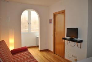 ein Wohnzimmer mit einem Sofa und einem TV in der Unterkunft BCN 324 Apartment in Barcelona