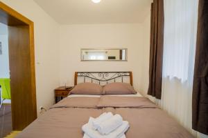 a bedroom with a bed with two towels on it at Studio Ztracená 8 in Olomouc