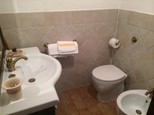 La salle de bains est pourvue d'un lavabo blanc et de toilettes. dans l'établissement Casa a Santo Stefano di Sessanio, à Santo Stefano di Sessanio