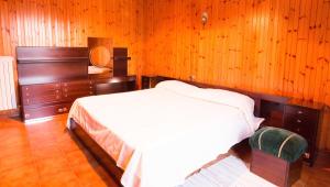 a bedroom with a bed and a wooden wall at Maurice des Alpes in Teglio