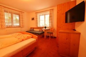 a bedroom with two beds and a flat screen tv at Haus Bergzauber in Neustift im Stubaital