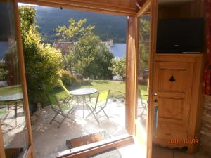 une porte coulissante en verre menant à une terrasse avec une table et des chaises. dans l'établissement Le chalet, à Briançon