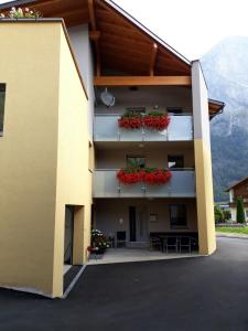 a building with flowers on the balconies of it at Ferienwohnung Mair in Umhausen