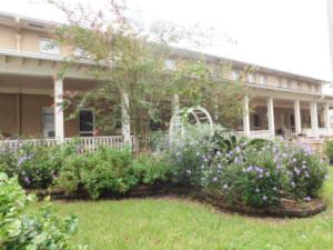 a garden in front of a house with flowers at Cassadaga Hotel and Spiritual Center in Cassadaga