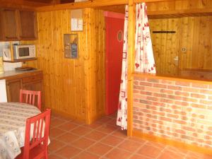 una cocina con una pared de ladrillo y una habitación con una mesa en Gite Waykiu, en Autrans