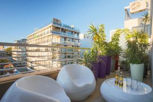 a balcony with two white chairs and a building at Gorriti Palace in Buenos Aires