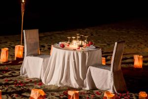 a table and two chairs with a white table and chairsearcher at Vichayito Bungalows & Carpas by Aranwa Hotels in Vichayito +143 photos