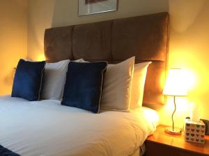 um quarto com uma cama com almofadas azuis e brancas em Rochester Apartment em Londres