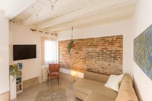 uma sala de estar com um sofá e uma parede de tijolos em Cà Biennale, respirare la Venezia autentica! 0-27042-LOC-13975 Z07763 em Veneza