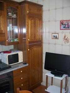 a small kitchen with a microwave and a television at Affittacamere Stella Marina in Piombino