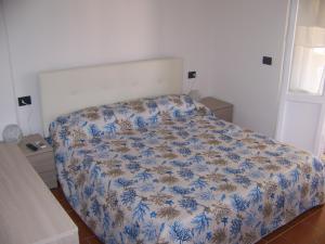 a bedroom with a bed with a blue and white comforter at Affittacamere Stella Marina in Piombino