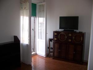 a television sitting on a dresser in a living room at Affittacamere Stella Marina in Piombino