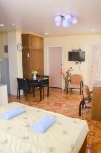 een woonkamer met 2 bedden en een tafel bij Julz Tropical Apartments in Olongapo