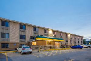 a large building with cars parked in a parking lot at Super 8 by Wyndham Iowa City/Coralville in Coralville