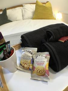 a bed with a bag of food and snacks on a table at Parsons Street in Dudley