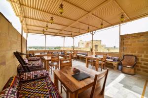 un ristorante con tavoli e sedie in legno e finestre di Shanti Home a Jaisalmer