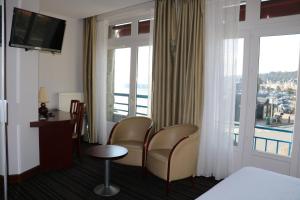 a hotel room with chairs and a window with a view at La Mere Champlain in Cancale