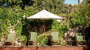 un grupo de sillas y una sombrilla en un patio en Home Hotel en Buenos Aires