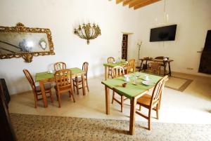 a dining room with green tables and wooden chairs at Finca Sa Duaia de Dalt in Artá