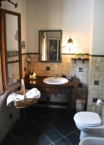 a bathroom with a sink and a toilet and a mirror at Casale la Decima in Budrio