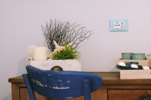 una silla azul sentada frente a una mesa con una planta en Echi del Mare, en La Spezia