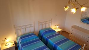 1 dormitorio con 2 camas y 2 luces en la pared en CasaAle, en Alghero