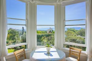 comedor con ventanas, mesa y sillas en Fairholme Manor Inn en Victoria