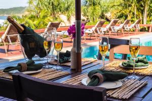 a table with wine glasses and a bottle of wine at Vida Sol e Mar Ecoresort in Praia do Rosa