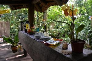 a table with dishes and plants on a patio at Pousada Favo De Mel in Ilha do Mel