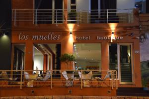 a hotel building with chairs on a balcony at night at Los Muelles Boutique Hotel in Carmelo