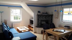 a living room with a blue couch and a table at Ferienpark An der Seebrücke in Ostseebad Koserow