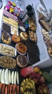 a table topped with lots of different types of food at Hotel Anjo Gabriel in Penha