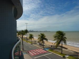 vistas a una playa con palmeras y un autobús en Manaira Palace Residence, en João Pessoa
