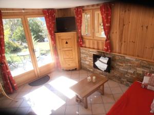 a living room with a fireplace and a table at Chalet Bon Accueil in Briançon +7 photos