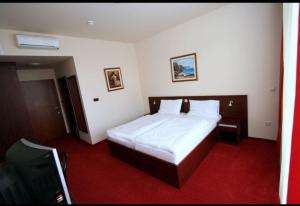 een hotelkamer met een bed en een televisie bij Lux Hotel Pansion in Jablanac