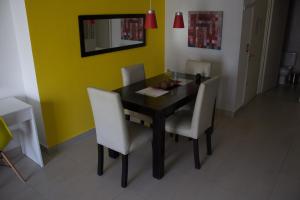 a dining room with a black table and white chairs at Palermo Quenns - Apartament Premiun in Buenos Aires