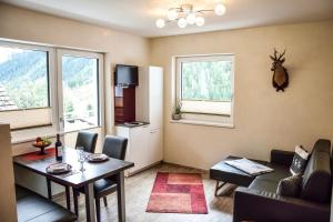 a living room with a dining room table and a kitchen at Apart Belvita in Sankt Leonhard im Pitztal