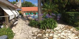 einen Hinterhof mit einem Pool und einem Garten mit Blumen in der Unterkunft Green Hotel in Pilar