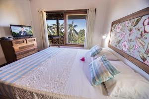 a bedroom with a large bed and a television at Vida Sol e Mar Ecoresort in Praia do Rosa +45 photos