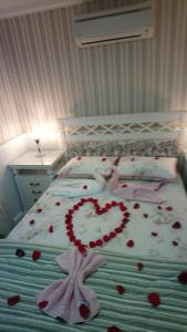 uma cama com um coração feito de corações vermelhos em Casa da Fabi em Gramado