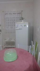a green plate on a table with a white refrigerator at Meu Cantinho da Paz Em Águas de Lindóia in Águas de Lindoia